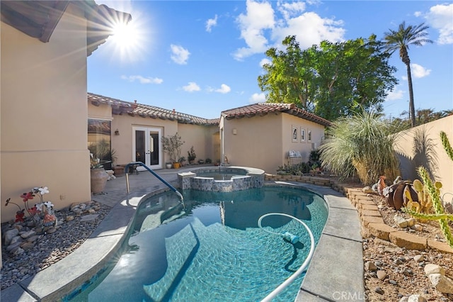 view of swimming pool featuring an in ground hot tub and french doors