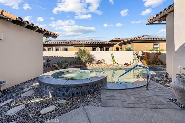 view of pool featuring a patio area, a fenced backyard, and a pool with connected hot tub