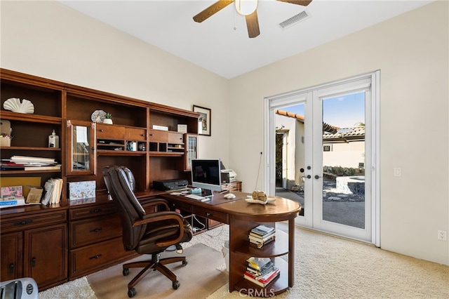 home office featuring light carpet, ceiling fan, french doors, and visible vents