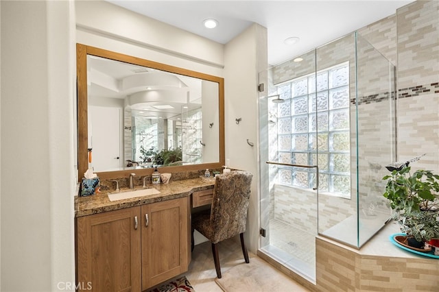 full bathroom with a wealth of natural light, a shower stall, and vanity