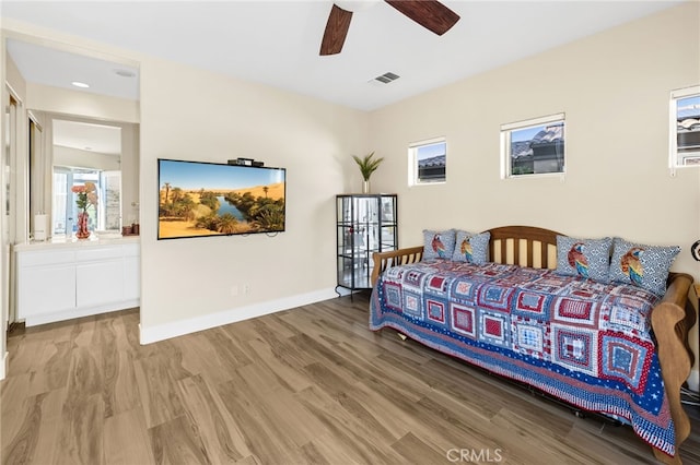 bedroom with visible vents, a ceiling fan, connected bathroom, wood finished floors, and baseboards