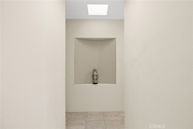 interior space featuring a skylight and tile patterned flooring