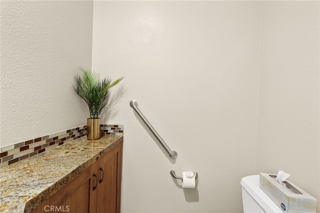 half bath featuring toilet and backsplash