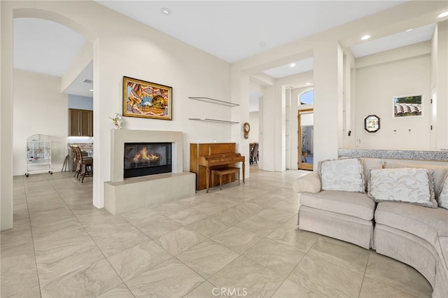 living area with recessed lighting and a glass covered fireplace