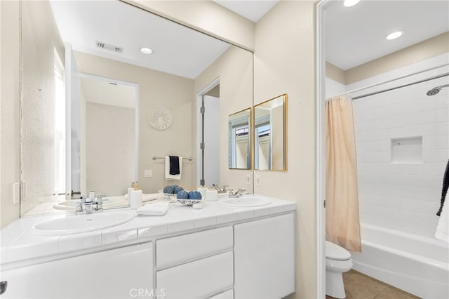 bathroom featuring toilet, visible vents, a sink, and tile patterned floors