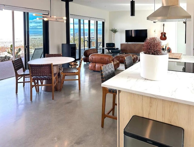 dining area with a wood stove and concrete floors