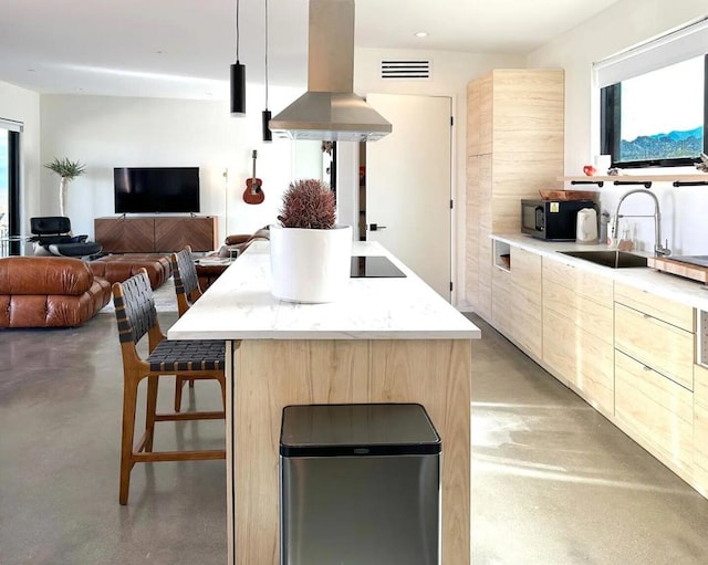 kitchen featuring sink, a kitchen breakfast bar, a center island, black appliances, and island exhaust hood