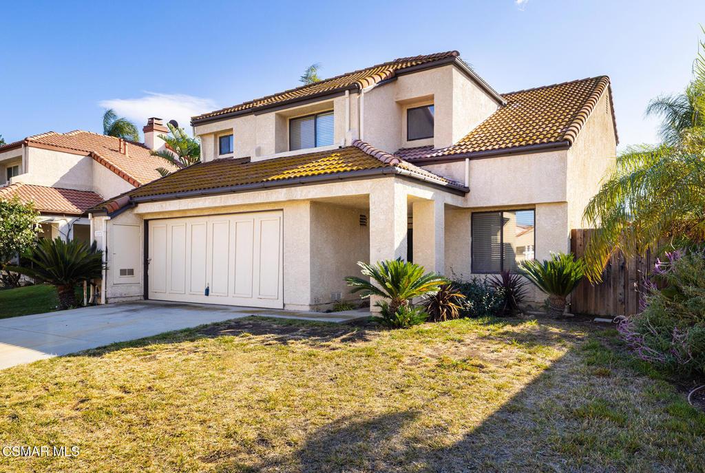 mediterranean / spanish-style house with a garage and a front lawn