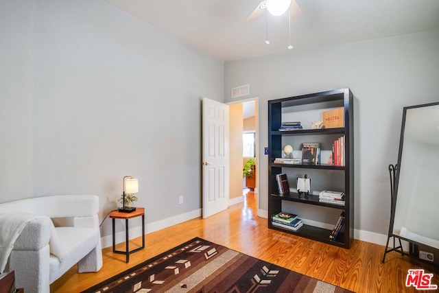 living area with hardwood / wood-style flooring and ceiling fan