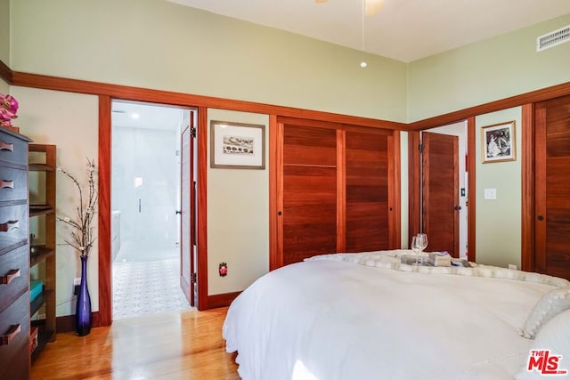 bedroom with light hardwood / wood-style floors and a closet