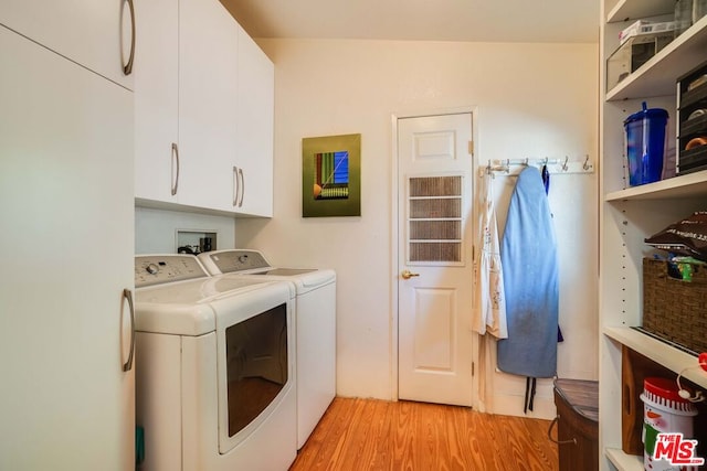 clothes washing area featuring cabinets, independent washer and dryer, and light wood-type flooring