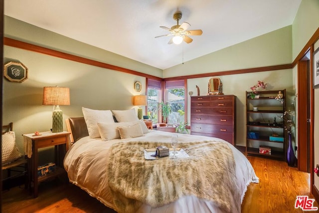 bedroom with hardwood / wood-style flooring, vaulted ceiling, and ceiling fan