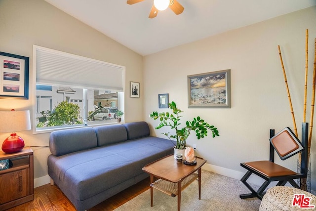 living room featuring wood-type flooring, ceiling fan, and vaulted ceiling