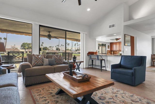 tiled living room with ceiling fan and high vaulted ceiling