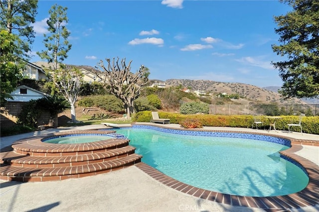 view of swimming pool featuring an in ground hot tub and a mountain view