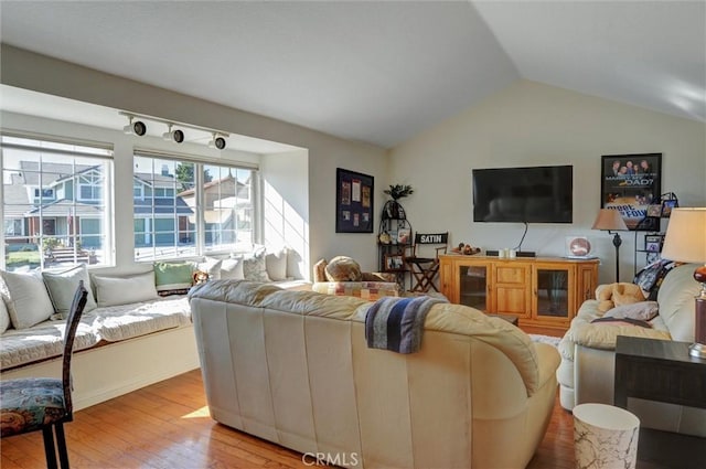 living room featuring lofted ceiling and light hardwood / wood-style floors