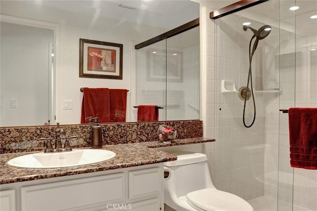 bathroom featuring walk in shower, vanity, and toilet