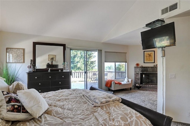 bedroom with vaulted ceiling, carpet floors, access to outside, and a fireplace