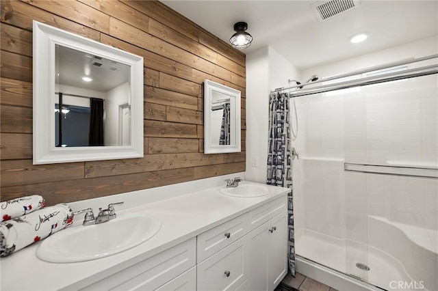 bathroom with an enclosed shower, vanity, and wooden walls