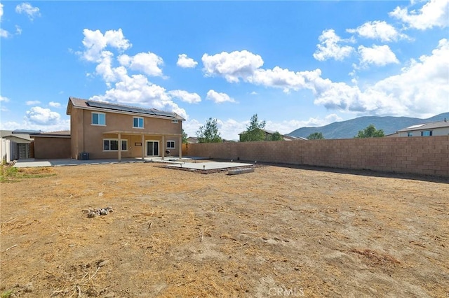 rear view of house with a mountain view and a patio