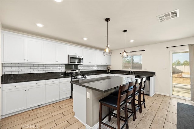 kitchen featuring white cabinetry, stainless steel appliances, and a center island