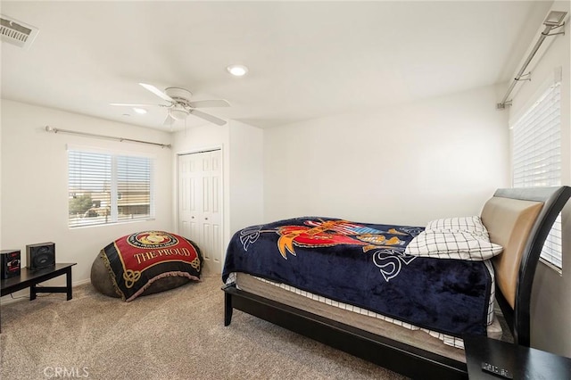 carpeted bedroom featuring ceiling fan and a closet