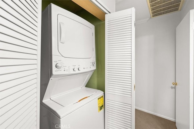 laundry area featuring light colored carpet and stacked washer and clothes dryer