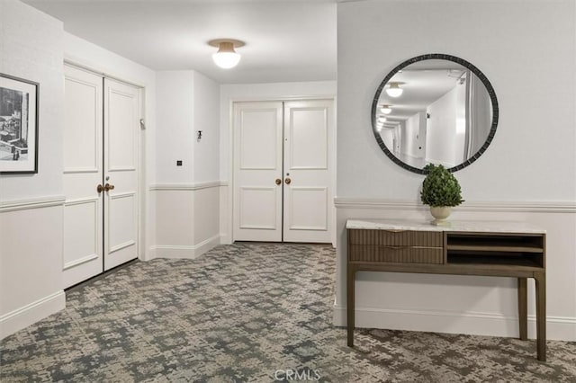 entrance foyer featuring dark carpet