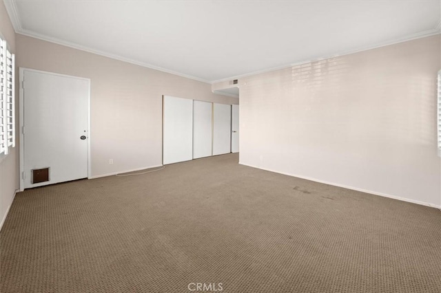 carpeted spare room featuring crown molding and plenty of natural light