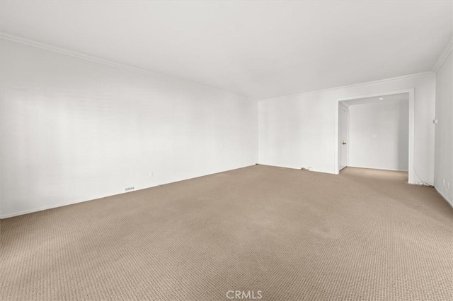 empty room featuring crown molding and light colored carpet