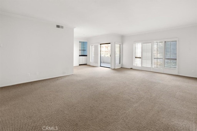 empty room with ornamental molding and light carpet