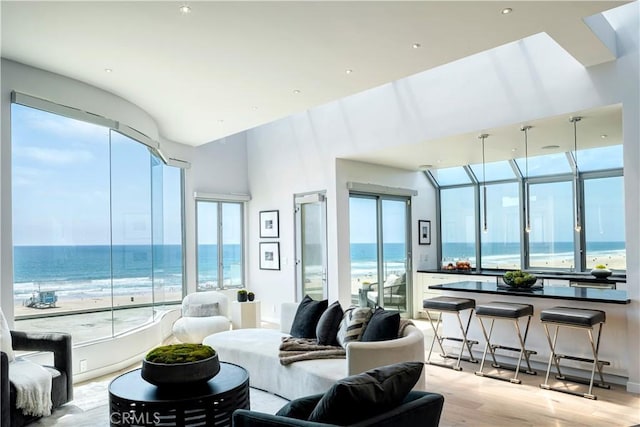 bedroom featuring a water view, a beach view, and light hardwood / wood-style floors