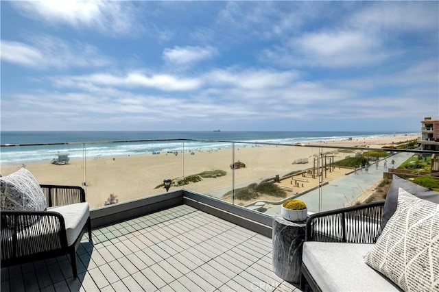 balcony with a water view and a view of the beach