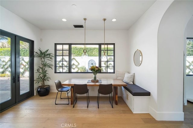 dining space featuring french doors, a wealth of natural light, light wood-type flooring, and breakfast area