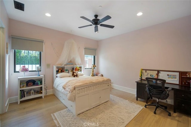 bedroom featuring multiple windows, ceiling fan, and light wood-type flooring