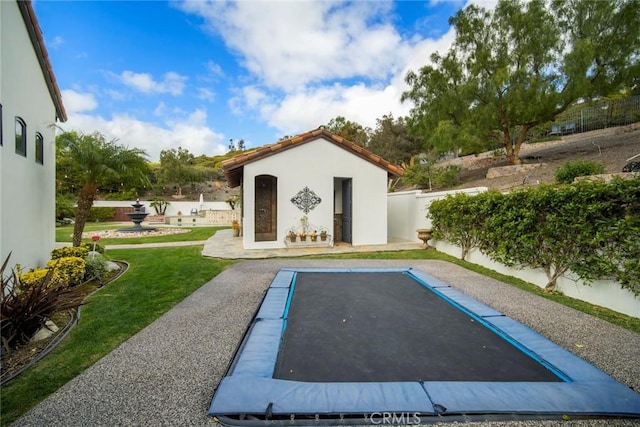 view of swimming pool with an outbuilding and a trampoline