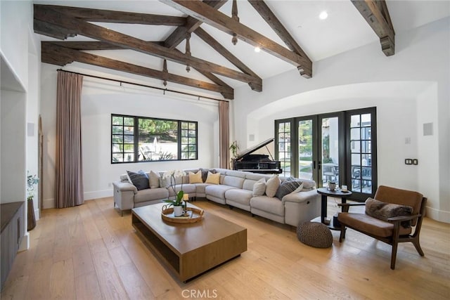 living room with high vaulted ceiling, light hardwood / wood-style floors, french doors, and beamed ceiling