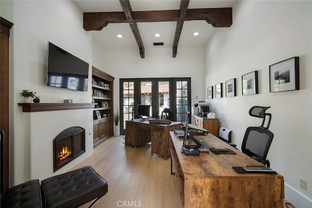 office area featuring light wood-type flooring, beam ceiling, and french doors