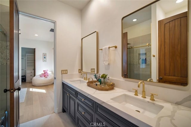 bathroom featuring vanity, an enclosed shower, and wood-type flooring