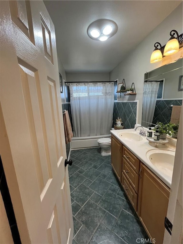 full bathroom featuring vanity, shower / bath combination with curtain, and toilet