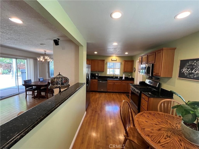 kitchen featuring appliances with stainless steel finishes, sink, dark hardwood / wood-style flooring, and plenty of natural light