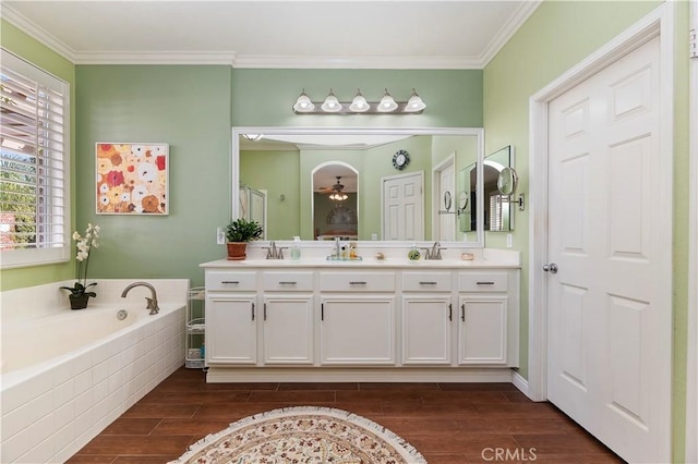 bathroom featuring a relaxing tiled tub, vanity, and ornamental molding