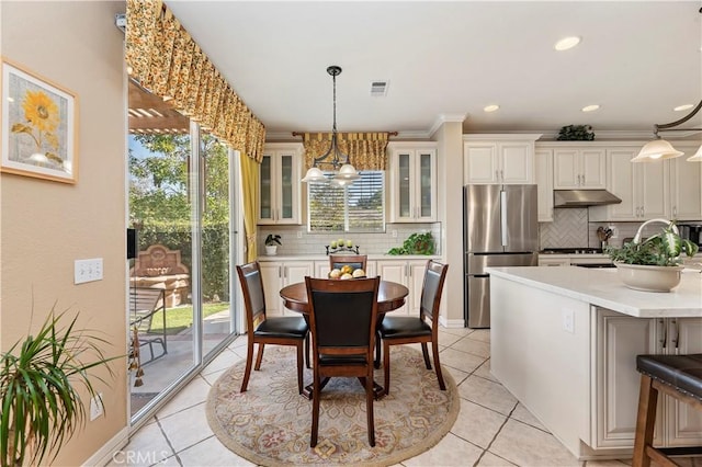 dining area featuring an inviting chandelier, sink, ornamental molding, and light tile patterned flooring