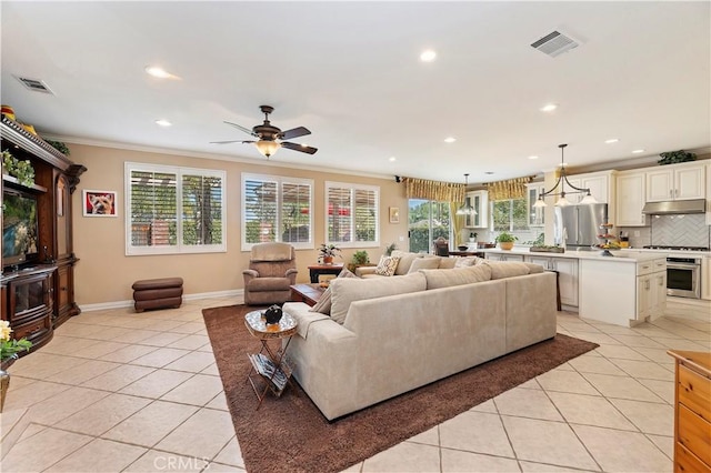 living room featuring crown molding, ceiling fan, and light tile patterned flooring