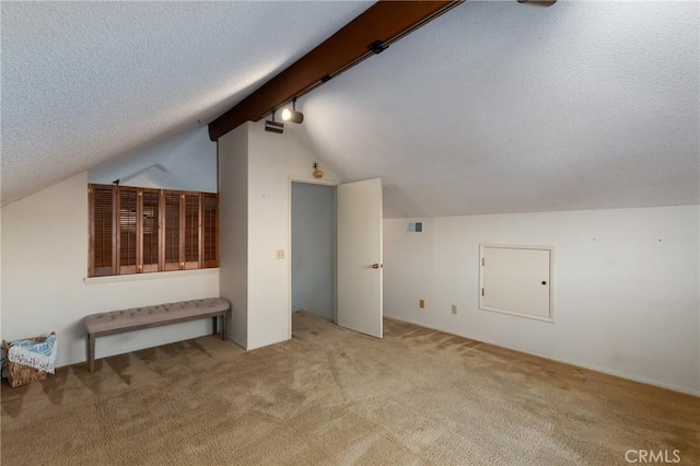 bonus room featuring lofted ceiling with beams, light carpet, and a textured ceiling