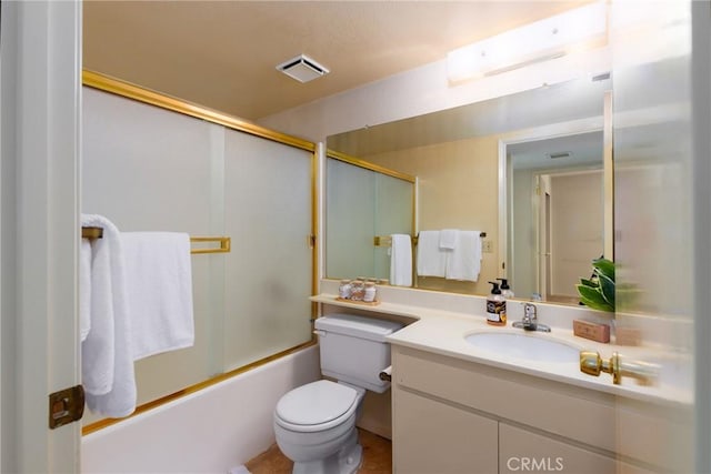 full bathroom featuring enclosed tub / shower combo, vanity, and toilet