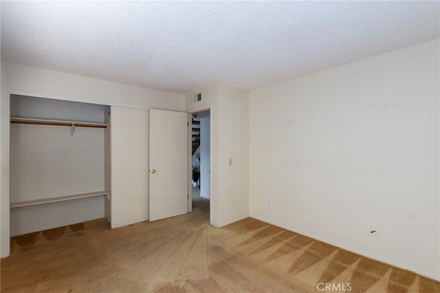 unfurnished bedroom with a closet, a textured ceiling, and carpet flooring