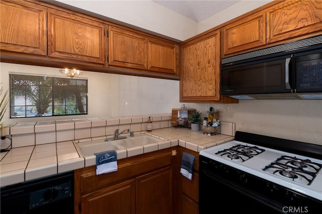 kitchen with tile countertops, sink, a textured ceiling, and black appliances