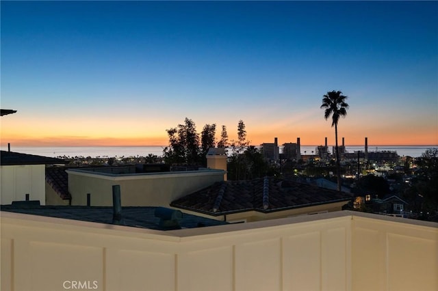 pool at dusk featuring a water view