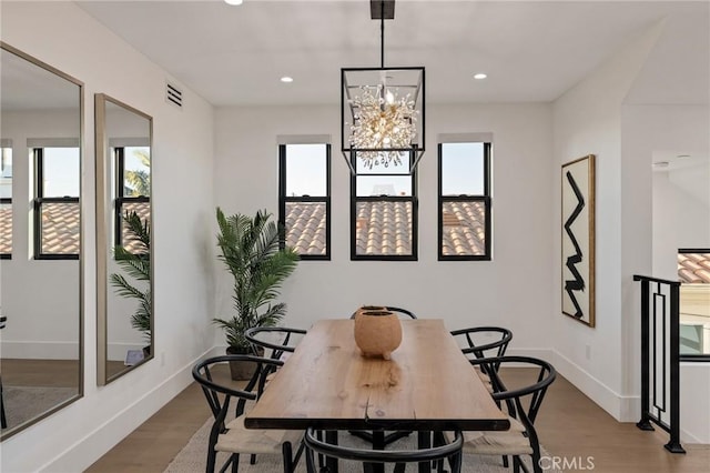 dining room with an inviting chandelier, light hardwood / wood-style floors, and a healthy amount of sunlight